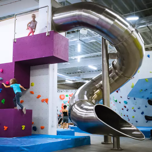Steel slide with climbing walls in an indoor sport hall